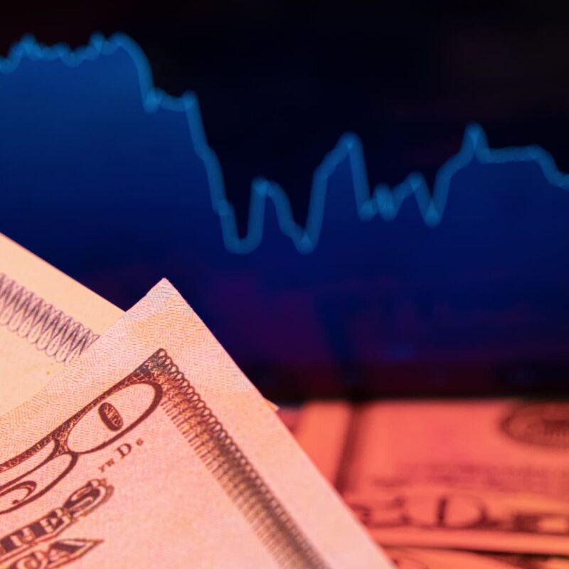 dollars-in-front-of-a-monitor-with-a-price-chart-2026-03-24-05-05-59-utc