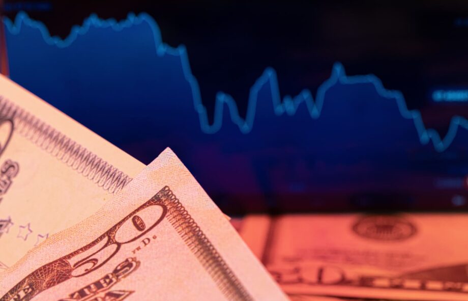 dollars-in-front-of-a-monitor-with-a-price-chart-2026-03-24-05-05-59-utc